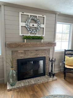 a living room with a fire place and a wreath on the fireplace mantel above it