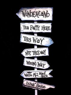 a wooden sign pointing in different directions with words on it that read wonderland, tea party here, this way, not this way, and wrong way