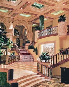 a large staircase in the middle of a building with potted plants on each side