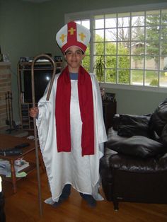 a man dressed in a costume with a crut and cross on it's head