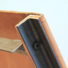 a knife sticking out of the side of a leather case that has been cut in half