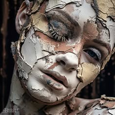 a woman with makeup on her face is covered in peeling paint and has eyelashes sticking out of her eyes