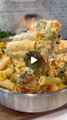 a pan filled with pasta and broccoli being lifted from the pot by a ladle