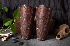 two brown vases sitting on top of a table next to a skull and bones