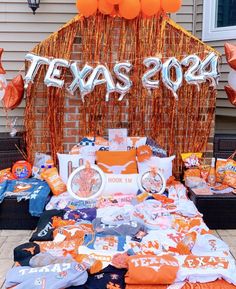 a bed covered in orange and white pillows next to a sign that says texas 2012