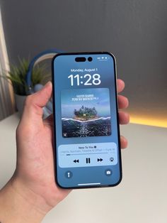 someone is holding up their iphone to show the time on it's display screen