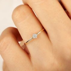 a woman's hand with a diamond ring on top of her finger, showing the side view