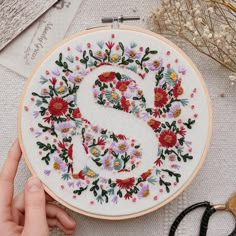 a hand embroidered letter s surrounded by flowers