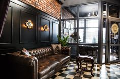 a living room with black walls and checkered flooring