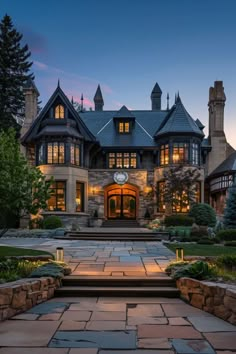 a large house with stone steps leading up to the front door and entry way at night