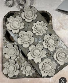 a metal tray filled with cupcakes on top of a table