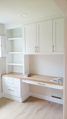 an empty room with white cabinets and drawers