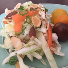 a salad with carrots, radishes and other vegetables on a blue plate