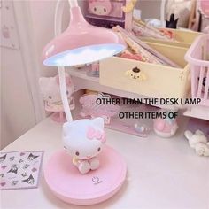 a hello kitty lamp sitting on top of a table next to a teddy bear bed