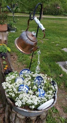 a potted planter filled with flowers next to a watering can and water faucet