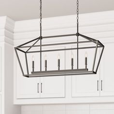 a light fixture hanging from the ceiling over a kitchen counter top with cabinets in the background