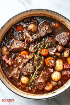 beef stew with carrots, potatoes and parsley in a pot on a marble surface