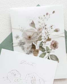 two cards with flowers on them are next to each other and one has an envelope