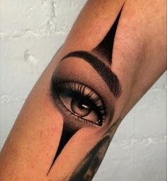 a woman's arm with an eye and eyebrows tattoo on the upper half of her leg