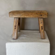 a wooden bench sitting on top of a white block