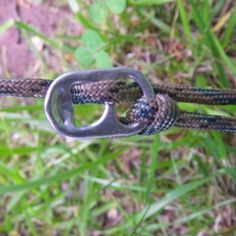 a close up of a rope with a metal buckle on it and grass in the background