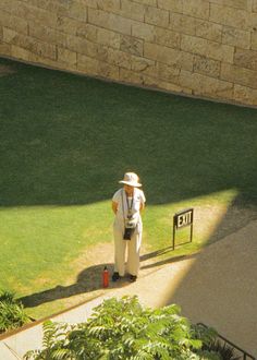 a man standing in the grass next to a sign