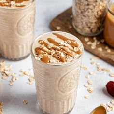 two glasses filled with peanut butter and oatmeal on top of a table