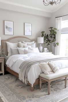 a bedroom with a large bed and white linens on the pillows, along with a chandelier