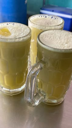 two mugs filled with liquid sitting on top of a table