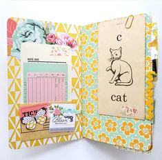 an open book with various papers and pictures on the pages, including a cat sticker