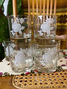 four glasses sitting on top of a wooden table