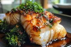 some kind of fish on a plate with broccoli