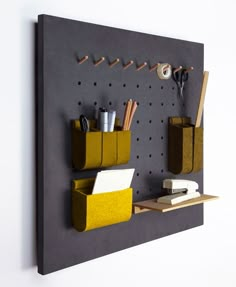 a black and yellow wall mounted shelf with office supplies on it