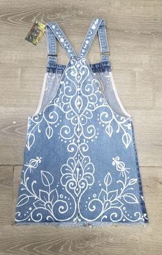 an apron made out of denim with white flowers on it