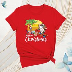 Mele Kalikimaka Christmas Shirt, Merry Hawaiian Santa Christmas Shirt, Beach Xmas Team Tee, Tropical Christmas Shirt, Coastal Party Xmas Tee Celebrate the season island-style with our Mele Kalikimaka Christmas Shirt! This festive Merry Hawaiian Santa Christmas Shirt brings tropical vibes to your holidays. Perfect for a Beach Xmas Team Tee or a fun Tropical Christmas Shirt at your next coastal party. Whether you're looking for a Santa Christmas Tee or a unique Coastal Party Xmas Tee, this Kalikimaka Christmas Shirt adds a Hawaiian twist to your Christmas celebrations. Ideal for holiday gatherings, this Island Christmas Tee is your go-to Christmas Party Tee for 2024! Mele Kalikimaka Christmas Shirt: How To Order: - Please, check all tees color and  size charts. - Select your shirt size, colo Casual New Year Tops, Casual Holiday Tops For New Year, Christmas Graphic Tee Shirt For Holiday, Christmas Holiday Crew Neck Shirt, Christmas Holiday Shirt With Graphic Print, Christmas Holiday Graphic Print Shirt, Christmas Holiday T-shirt With Short Sleeves, Christmas Holiday Short Sleeve T-shirt, Red Christmas Shirt For Holiday