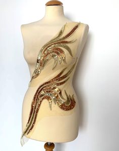 a white mannequin with gold and red designs on it's torso, against a white background