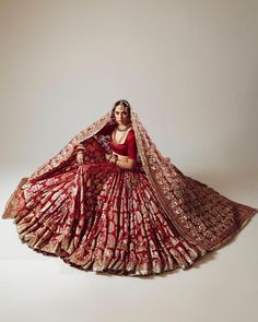 a woman in a red and gold bridal gown with a veil on her head