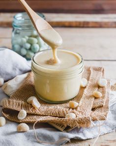 a spoon full of peanut butter sitting on top of a cloth next to a jar