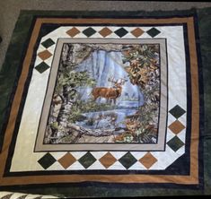 a quilt with an image of a deer in the woods on it's side