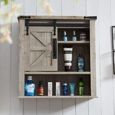 an old wooden medicine cabinet with bottles and other items on the shelf next to it