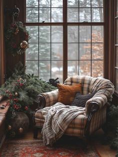 a plaid chair and christmas tree in front of a window