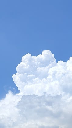 the airplane is flying high in the blue sky with clouds behind it and another plane on the ground below