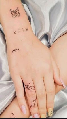 a woman's hand with a butterfly tattoo on her left arm and the date 2013