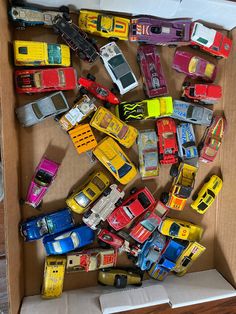 a cardboard box filled with lots of toy cars