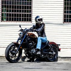 a person sitting on a motorcycle in front of a building