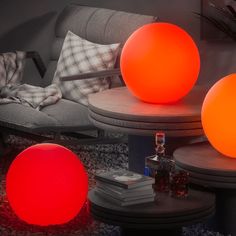 three orange balls sitting on top of a table in front of a couch and coffee table