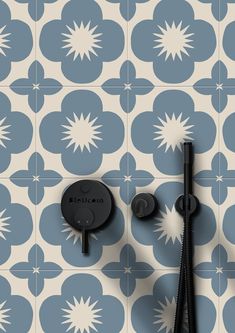 a black shower faucet sitting on top of a blue and white tiled wall