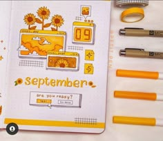 an open notebook with yellow markers and pens on the cover, next to some other items