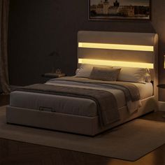 a bed that has some lights on the headboard and night stands in front of it