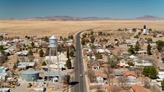 an aerial view of a small town in the middle of nowhere, with a water tower